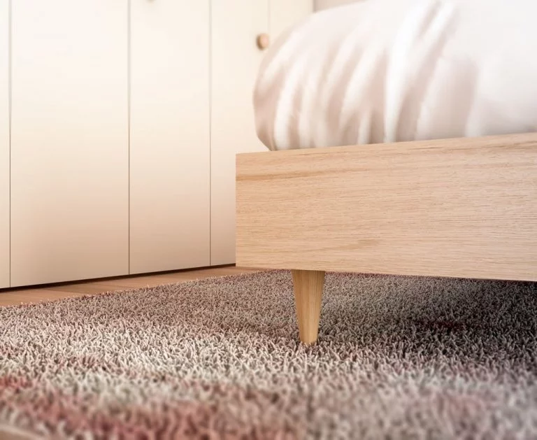 Detalle de la pata madera que tiene la cama